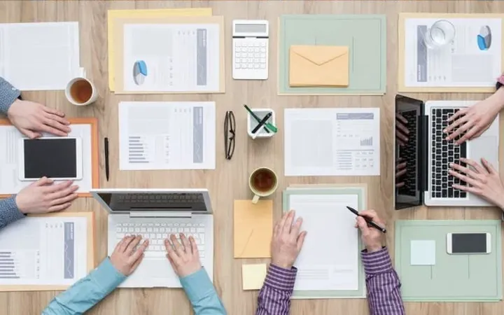 A team working around a shared desk, seen from above